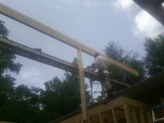 Carpenter setting a ridge beam over a new addition frame — Ice Dam Removal by Roofing Brothers in South Amboy