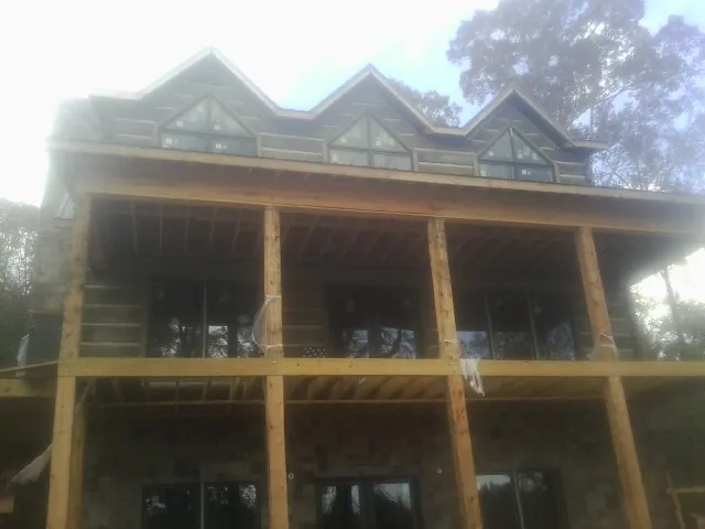 Dormers and porch framing on a large log home under construction — Roof Coating work by our crew in South Amboy